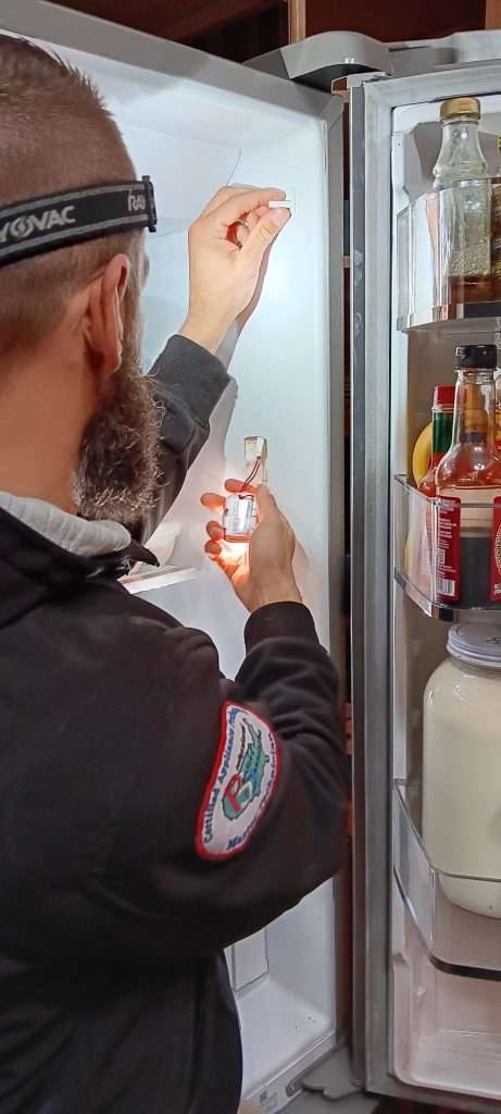 Dan of 877MRFIX06 working on a fridge light module.