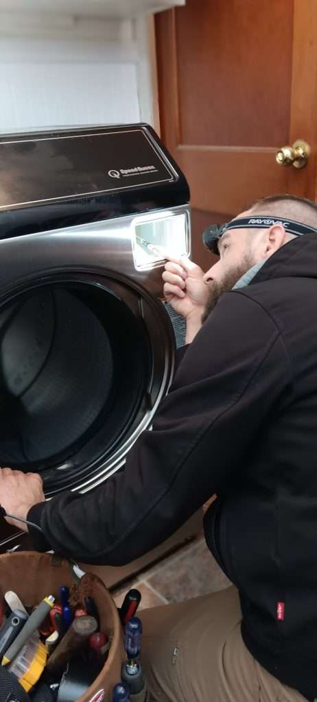 Dan Inspects The Dispenser Compartment On A Washer.